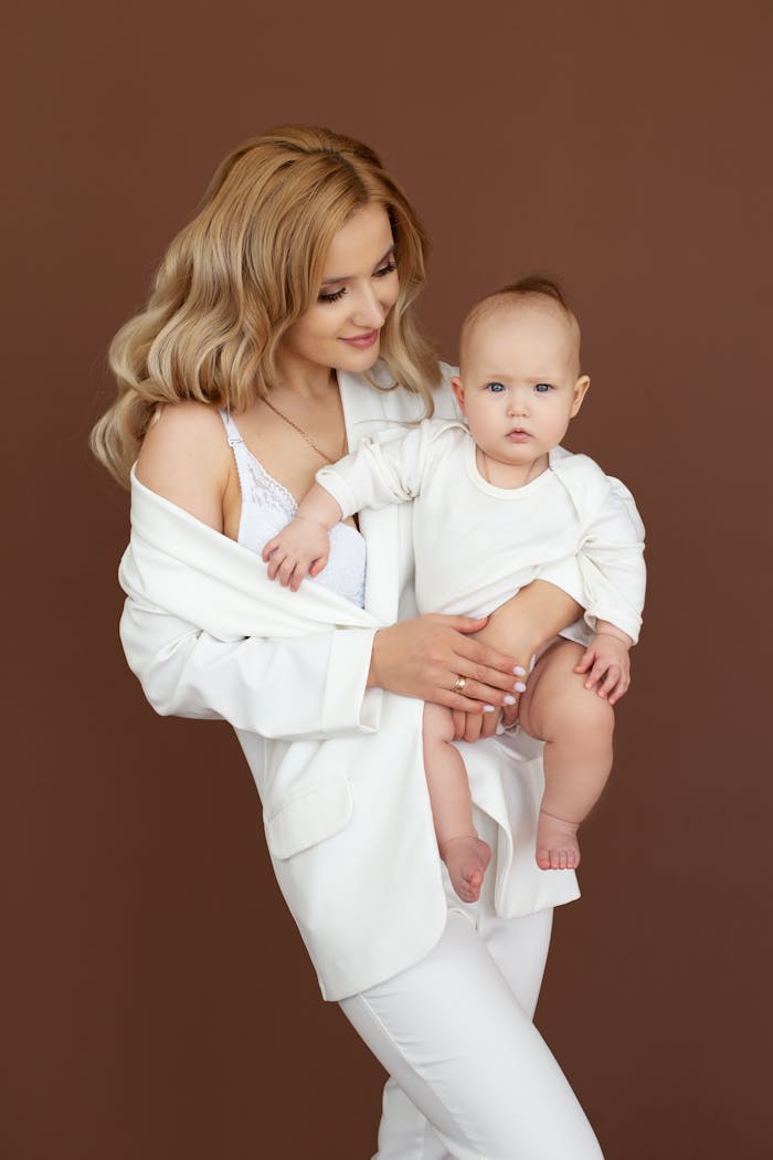 A loving mother holding her baby during a professional studio portrait session.